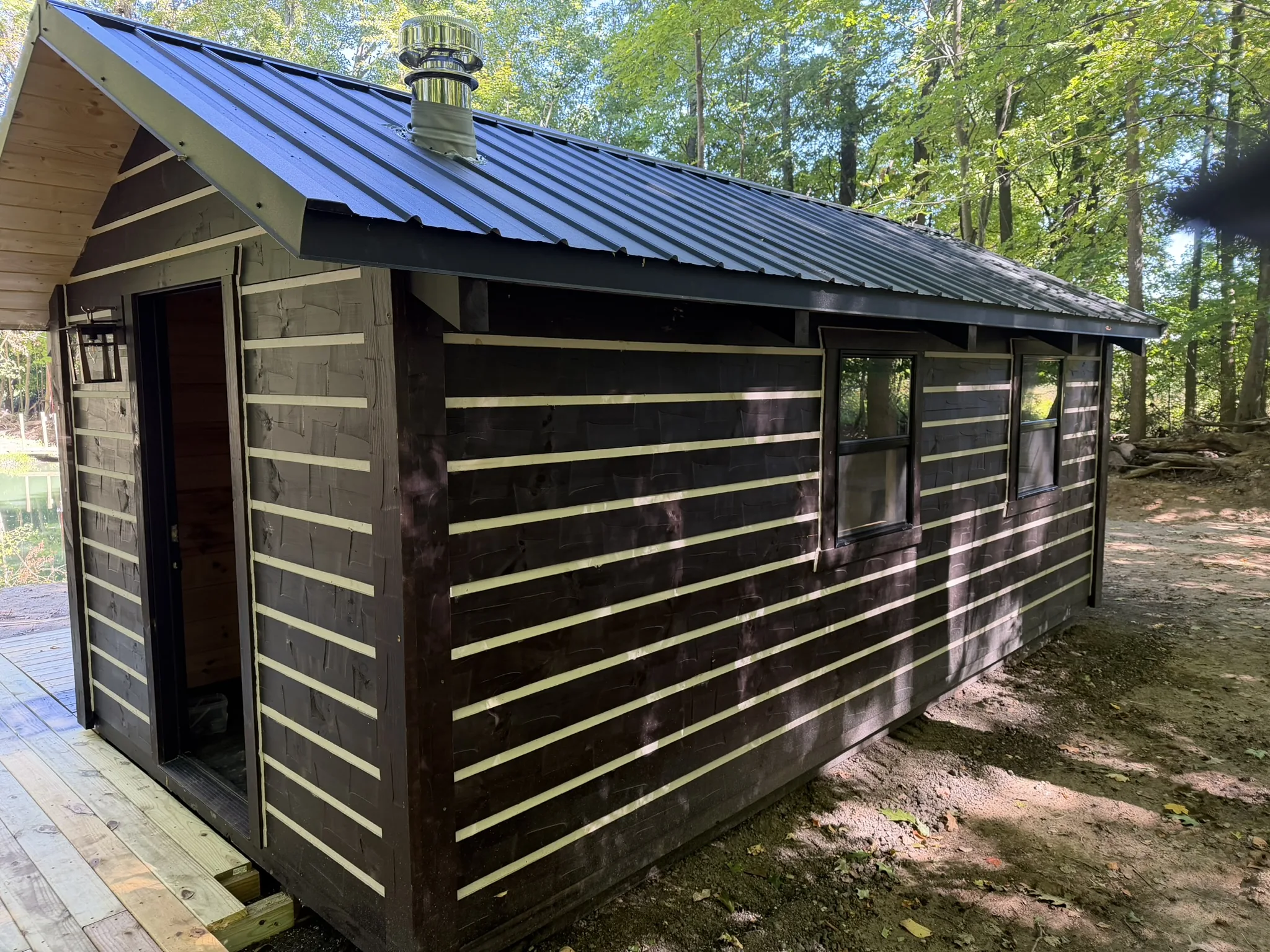 Orana cabin in a wooded lot beside a pond